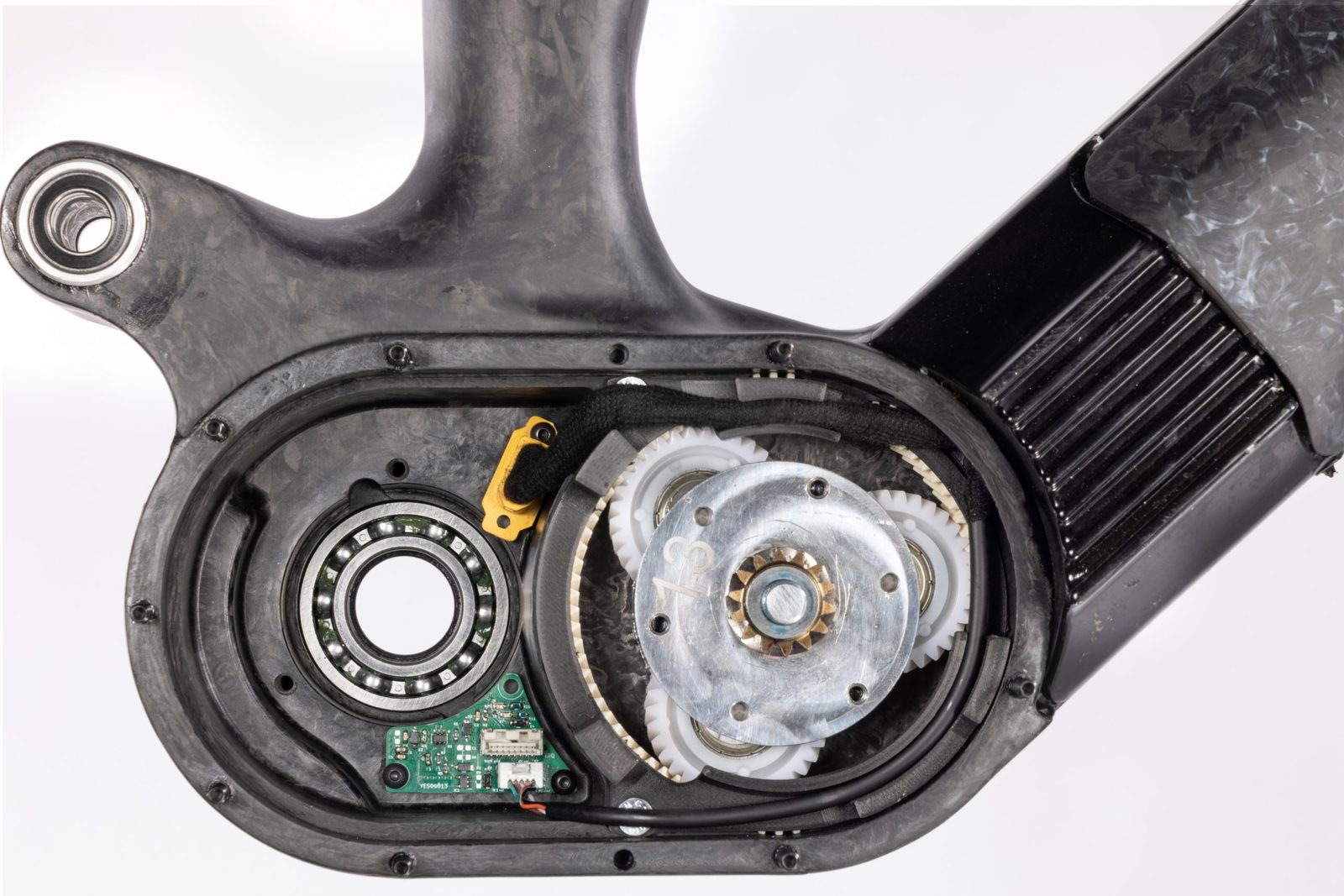 Power unit gear reduction and sensor board seated in a cavity molded into the forged-carbon frame