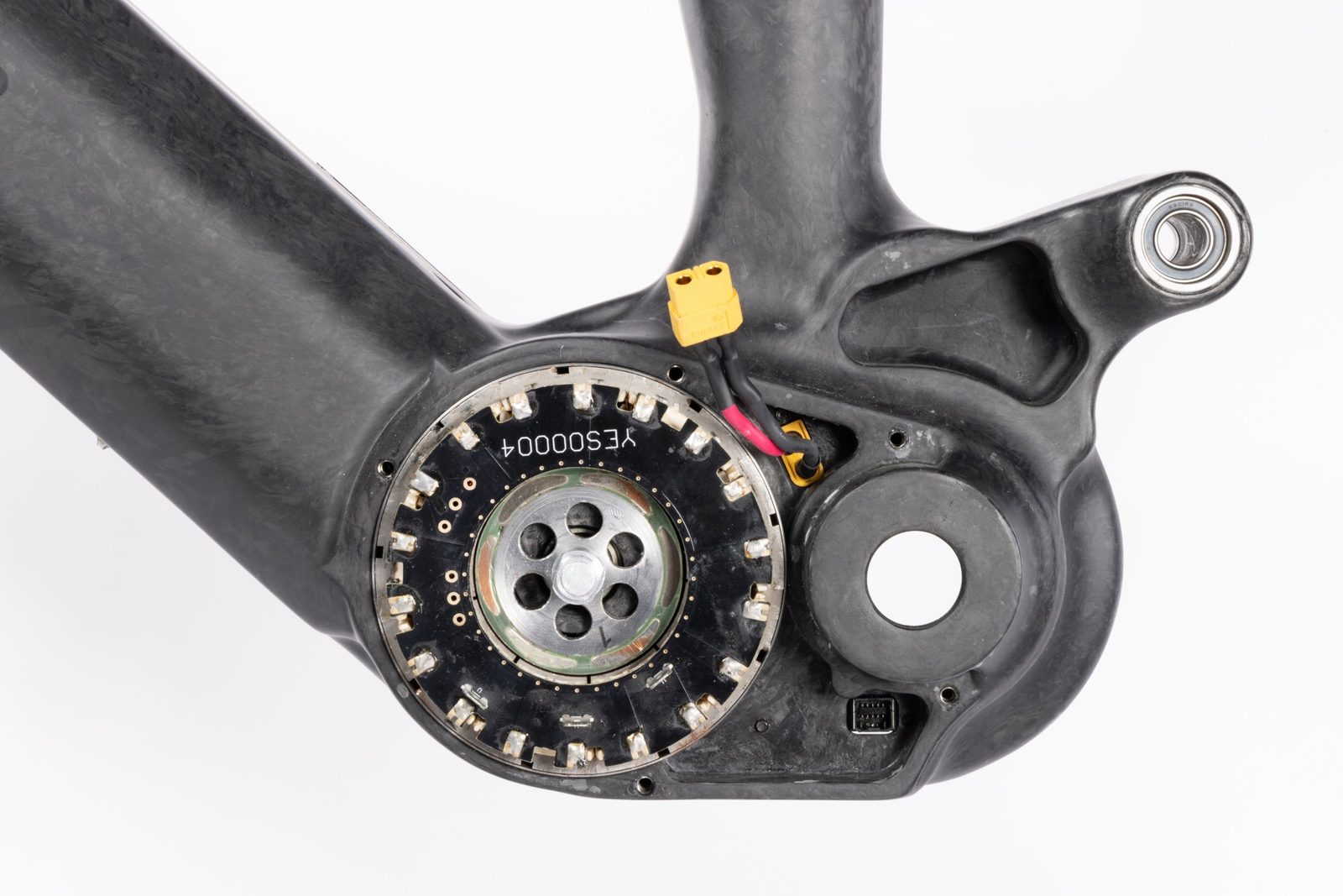 The motor with its cover removed, stator housed directly in the forged-carbon frame